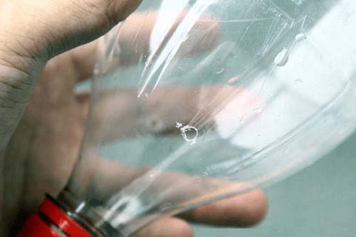 Xử lý chai nhựa bằng việc rửa sạch và khoét lỗ vừa phải dọc trên thân chai hoặc cắt ngang thân chai